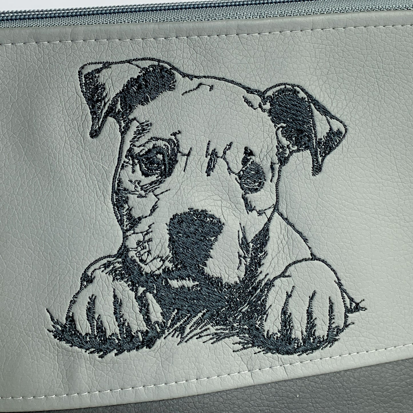 Detailaufnahme Stickmotiv auf dunkelgrauem Kunstleder