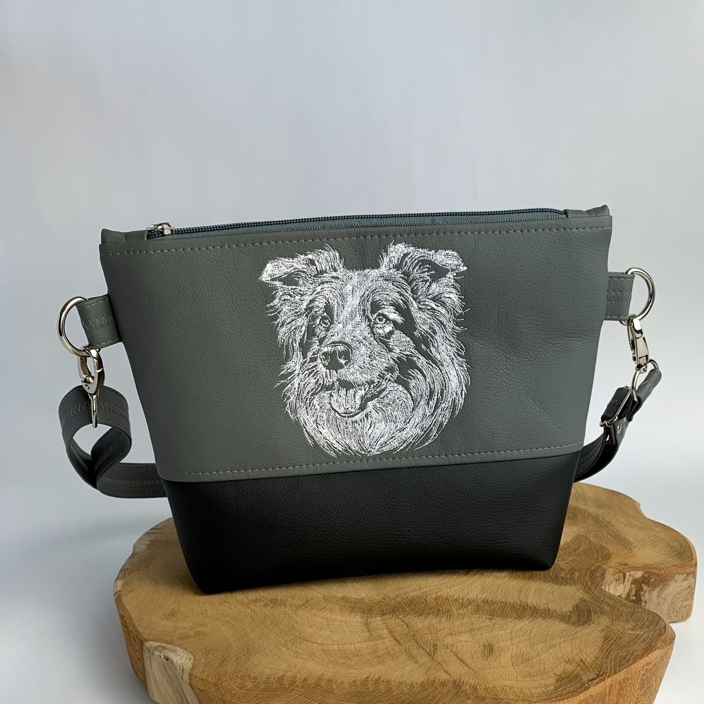 Umhängetasche mit Border Collie-Motiv bestickt, zweifarbig aus Kunstleder, oben dunkelgrau mit dem Kopf eines Border Collies bestickt in weiß, unten schwarz