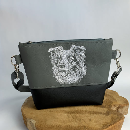 Umhängetasche mit Border Collie-Motiv bestickt, zweifarbig aus Kunstleder, oben dunkelgrau mit dem Kopf eines Border Collies bestickt in weiß, unten schwarz