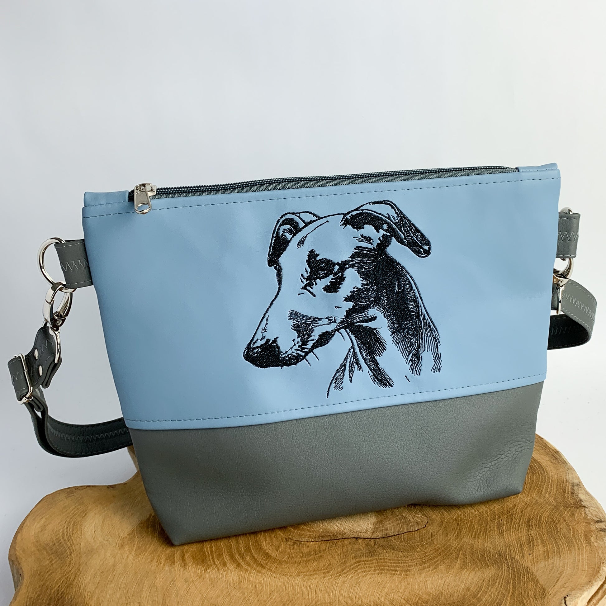 Whippet Tasche mit Hundemotiv, handgefertigt aus Kunstleder, zweifarbig, oben hellblau, unten dunkelgrau. Stickmotiv Whippet Kopf und Oberkörper detailreich gestickt als schwarze Kontur
